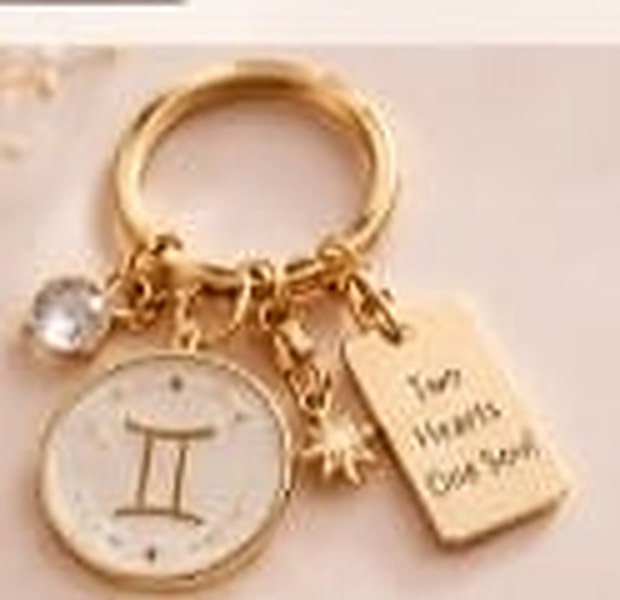 Gemini zodiac keychain with a gold ring, enamel sign disc, crystal, star charm and tag reading Two Hearts One Soul